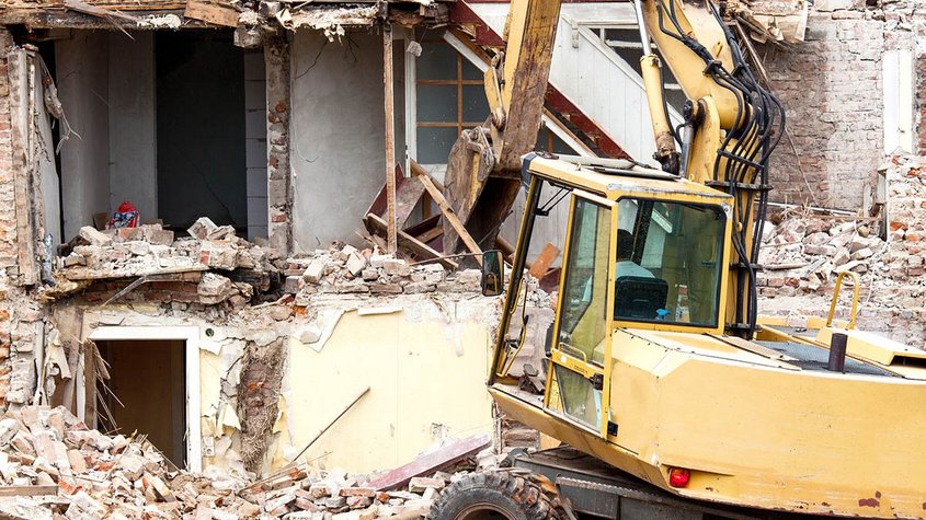 Bagger reißt ein Haus ein